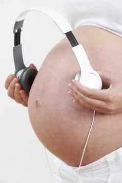 关闭怀孕了女人持有耳机肚子
