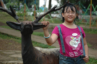 女孩站鹿雕像