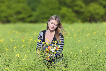 女人挑选野生花草地