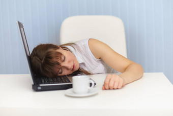 年轻的女人睡觉移动PC键盘工作场所