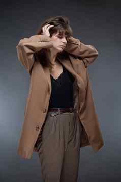 肖像年轻的女人棕色（的）外套