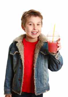 快乐健康的男孩持有新鲜的水果汁清晰的杯