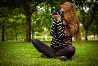 女摄影师坐着草