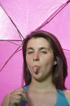 年轻的粉红色的伞坚持舌头
