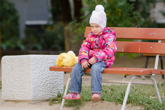 悲观的女孩秋天衣服坐着板凳上