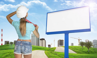 女人头盔站向后广告牌绿色山路建筑背景
