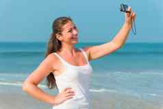 快乐浅黑肤色的女人拍摄海滩后无