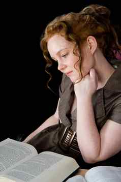 美丽的女孩红色的头发阅读书