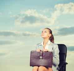 业务女人裙子上衣夹克坐着椅子背景天空云
