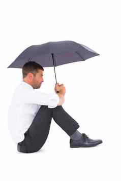 商人坐着地板上黑色的伞