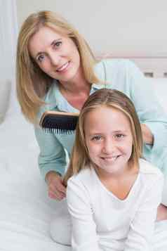 微笑妈妈。刷牙女儿头发