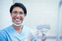微笑女牙医持有牙齿模型