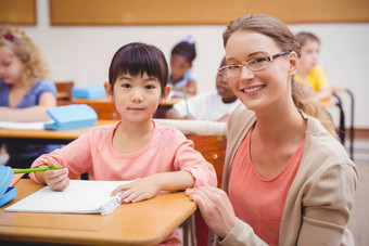 漂亮的老师帮助学生教室微笑相机