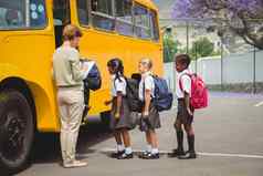 可爱的小学生等待学校公共汽车