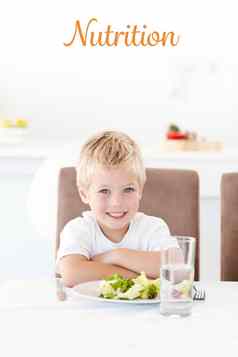 营养可爱的男孩准备好了吃沙拉午餐坐着表格