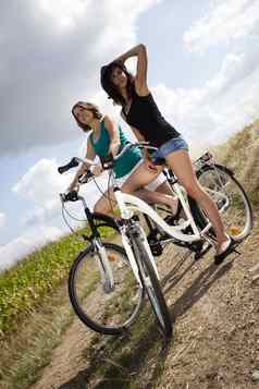 年轻的女人骑自行车夏天免费的时间支出