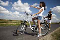 年轻的女人骑自行车夏天免费的时间支出