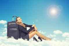 女人坐着云倾斜回来旅行袋微笑