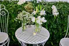 白色花安排玻璃花瓶白色金属桌子上