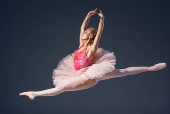 美丽的女芭蕾舞舞者灰色<strong>背景</strong>芭蕾舞女演员穿粉红色的图图尖端鞋子