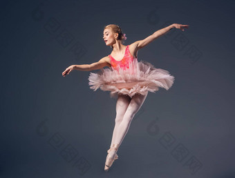 美丽的女芭蕾舞舞者灰色背景芭蕾舞女演员穿粉红色的图图尖端鞋子