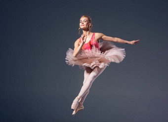 美丽的女芭蕾舞舞者灰色<strong>背景</strong>芭蕾舞女演员穿粉红色的图图尖端鞋子