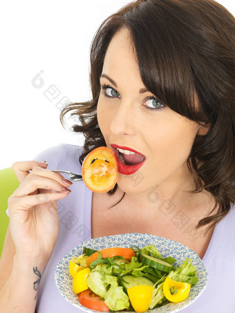 年轻的女人吃健康的混合沙拉