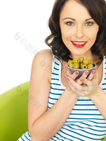 年轻的女人吃绿色橄榄