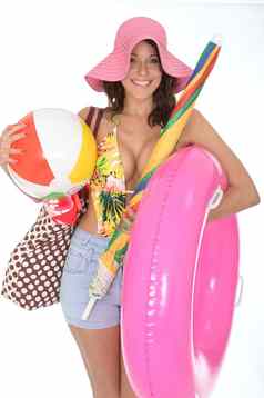 年轻的女人穿游泳西装假期携带海滩球