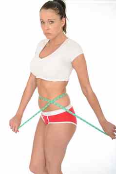健康的年轻的女人检查重量损失磁带测量