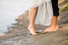 爱的年轻的夫妇拥抱接吻海滩日落