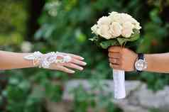 新郎传输给新娘婚礼花束白色玫瑰