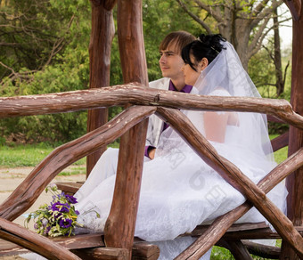 夫妇爱新娘新郎摆姿势坐着木板凳上