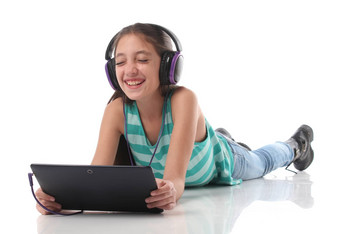 美丽的青少年女孩地板上强平板电脑电脑耳机
