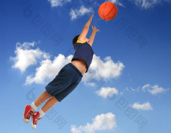 男孩玩篮球飞行蓝色的天空