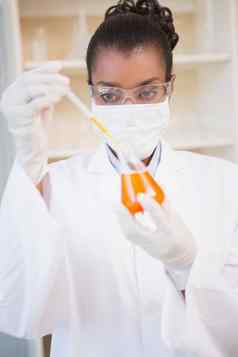 集中科学家检查橙色流体吸管