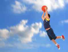 男孩玩篮球跳飞行