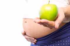 怀孕了女人持有绿色苹果