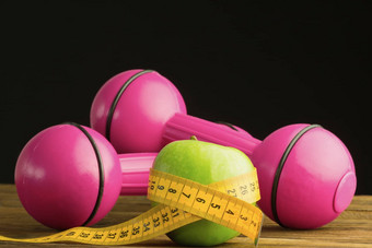 粉红色的哑铃绿色苹果测量磁带