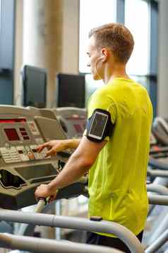男人。智能手机锻炼跑步机健身房