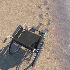 空轮椅海滩沙子的足迹概念背景