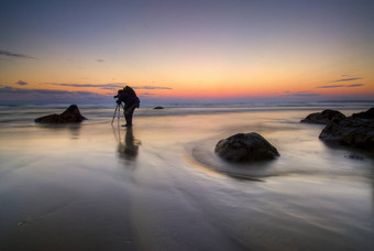 摄影师采取照片海滩黎明新西兰