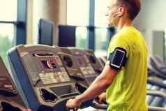 男人。智能手机锻炼跑步机健身房