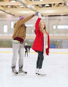 快乐夫妇持有手滑冰溜冰场