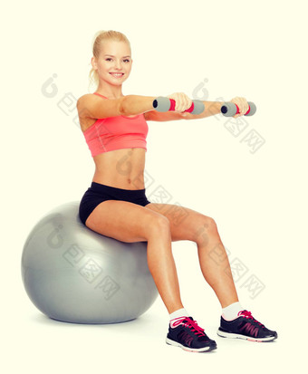 女人<strong>哑铃</strong>坐着健身球