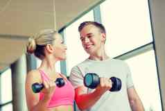 微笑年轻的女人个人教练健身房