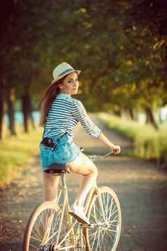 可爱的年轻的女人他骑自行车在户外活跃的