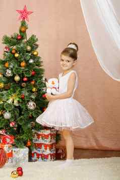 五年女孩站玩具雪人圣诞节树