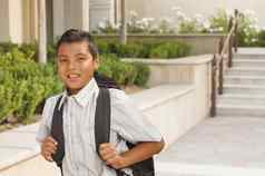 快乐拉美裔男孩背包走学校校园