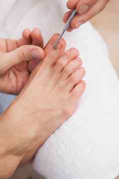 pedicurist清洁客户然后指甲